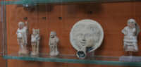 statuine in terracotta con un Askos a forma di volto umano 